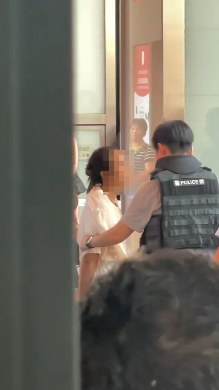 女子站起接受警方的盤問。 女子站起接受警方的盤問。