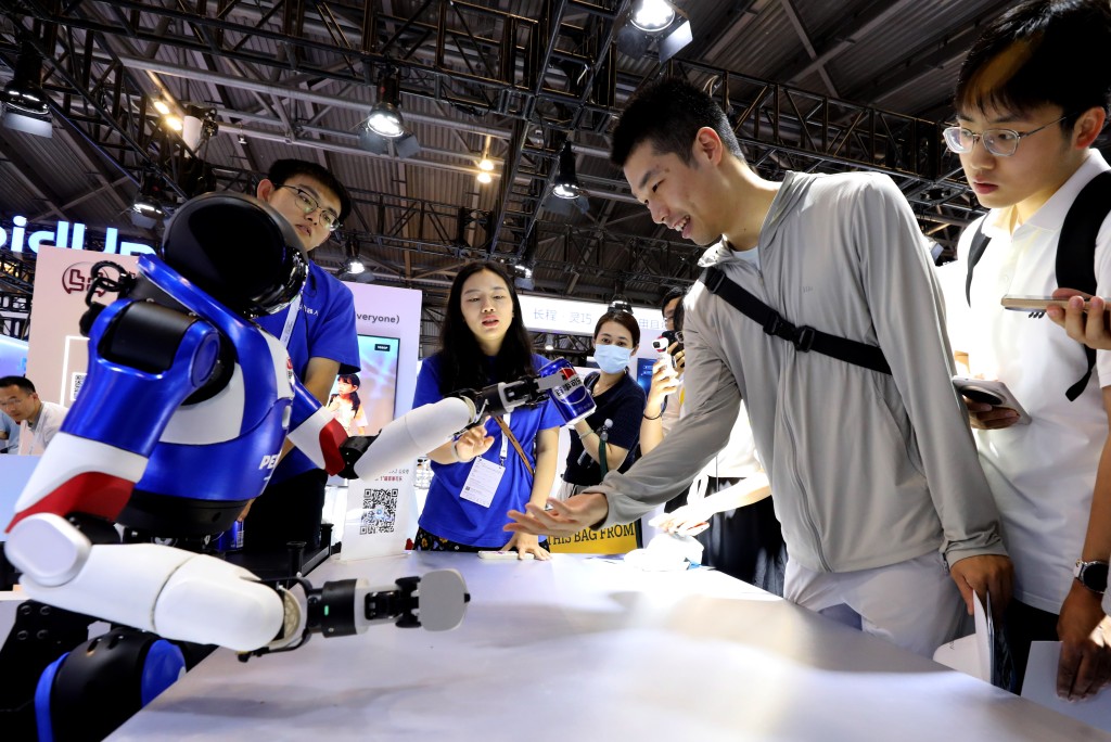 2025世界人工智能大會上，有機械人展示送贈禮品的功能。新華社