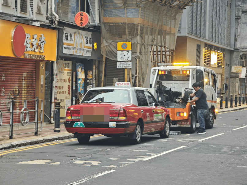 涉案的士被拖走。黎志偉攝 涉案的士被拖走。黎志偉攝