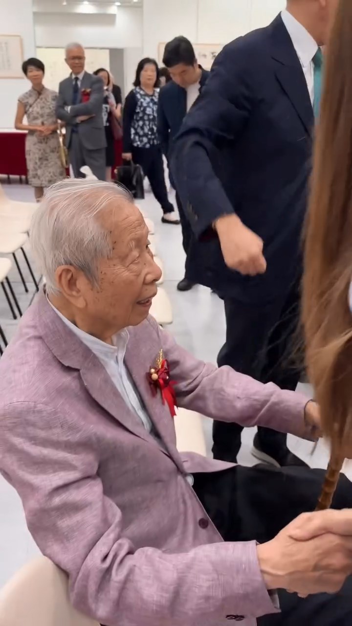 施伯雄的爺爺施子清握住一人之手。