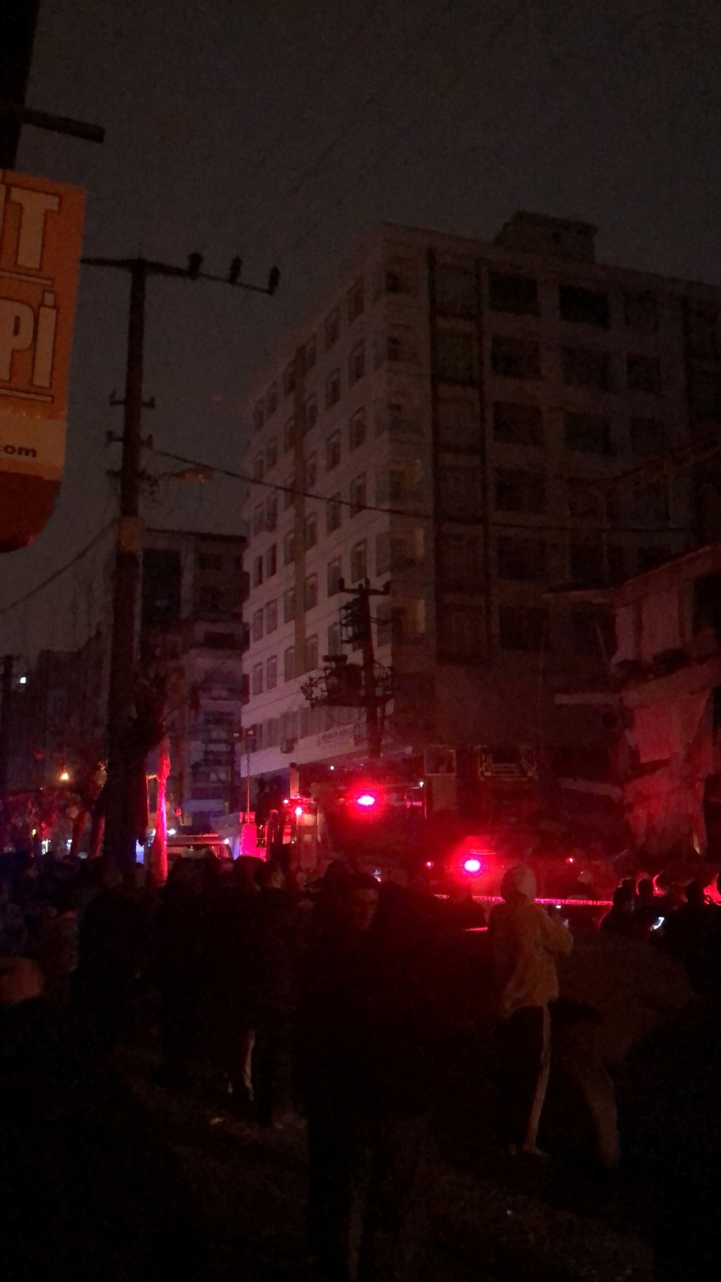土耳其发生地震后倒塌的建筑物附近出现了救援人员和紧急服务车辆。网图