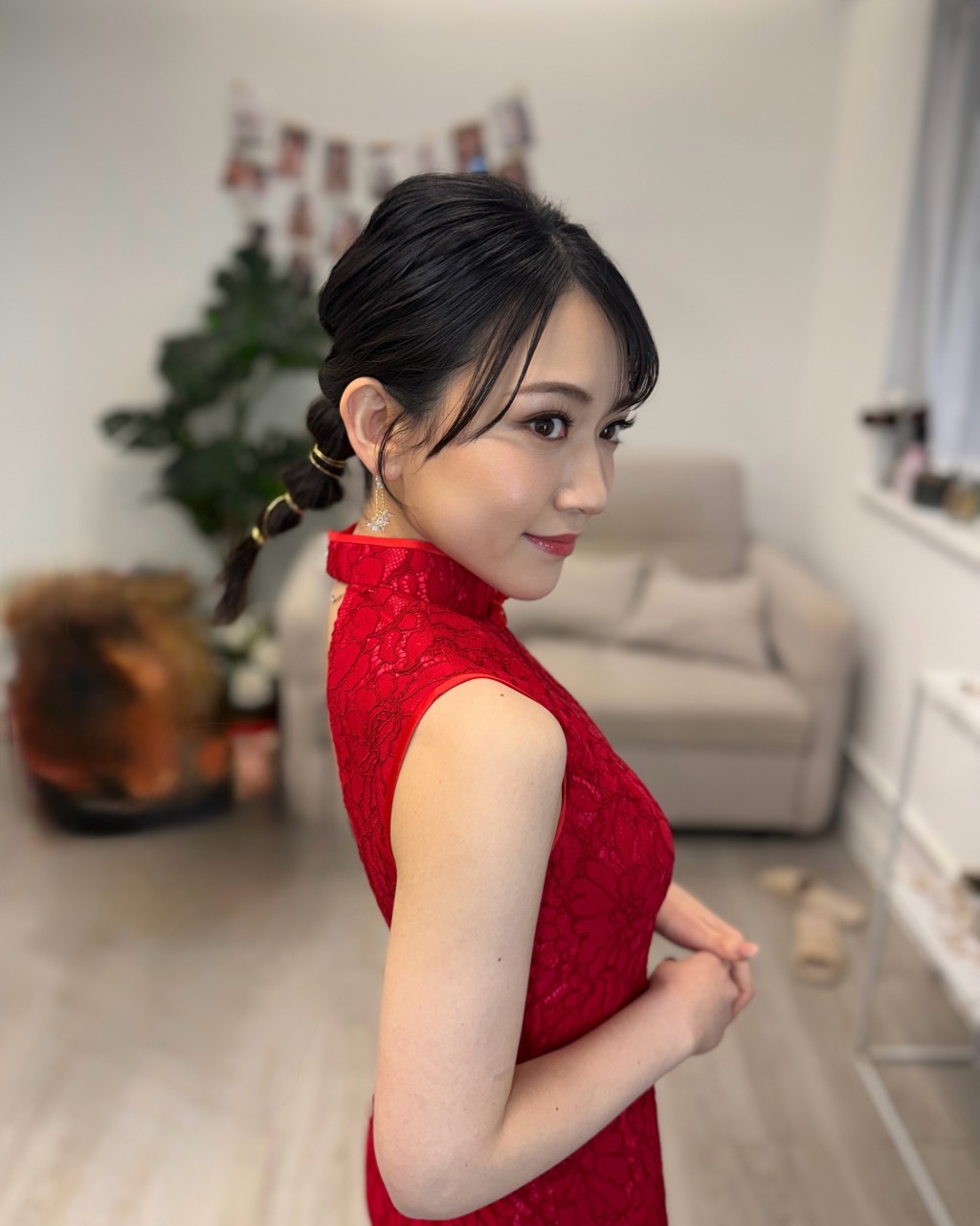 她的妝容精緻，與一身紅色旗袍打扮十分相襯。