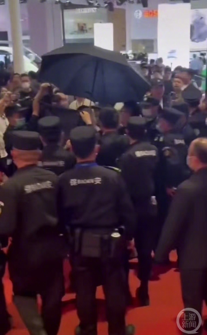 大批保安用黑布和黑傘遮擋將Tongtong拖走。