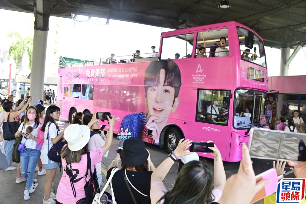 粉红色观光巴士在场接载乘客。