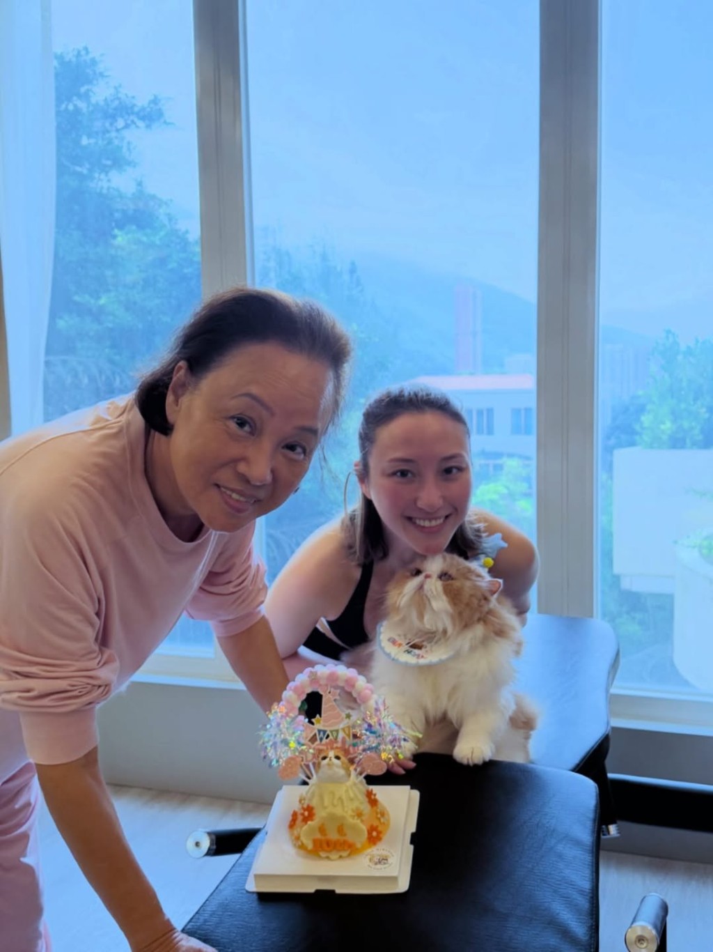 何超雲抱着寵物貓和媽媽陳婉珍合影。