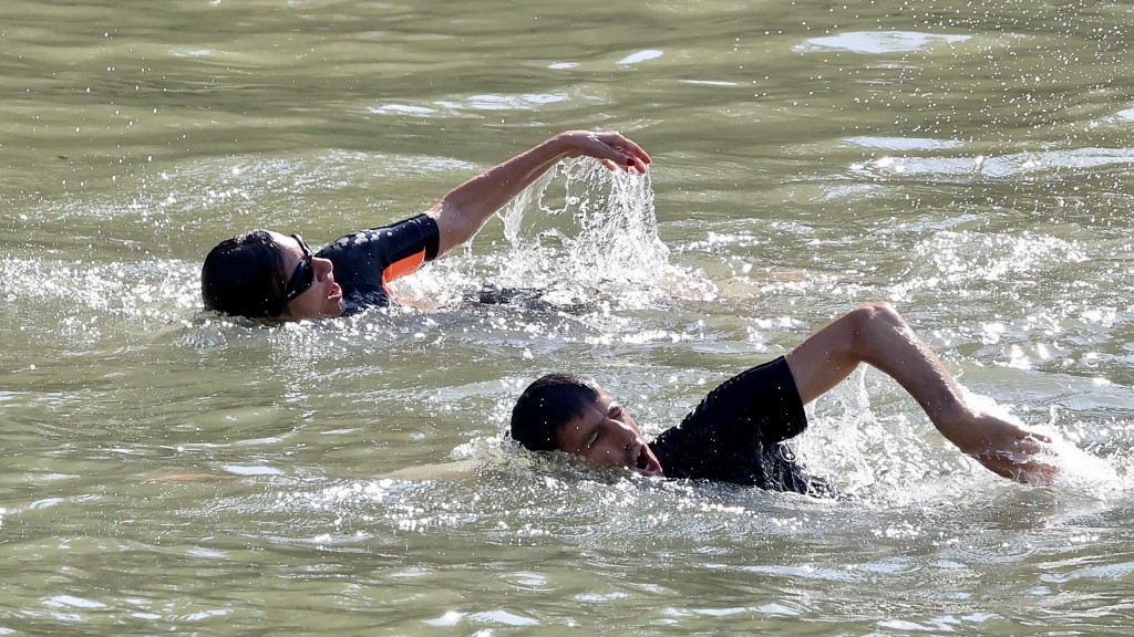 巴黎市長伊達爾戈（左）與巴黎奧組委主席埃斯坦蓋在塞納河中游泳。  新華社