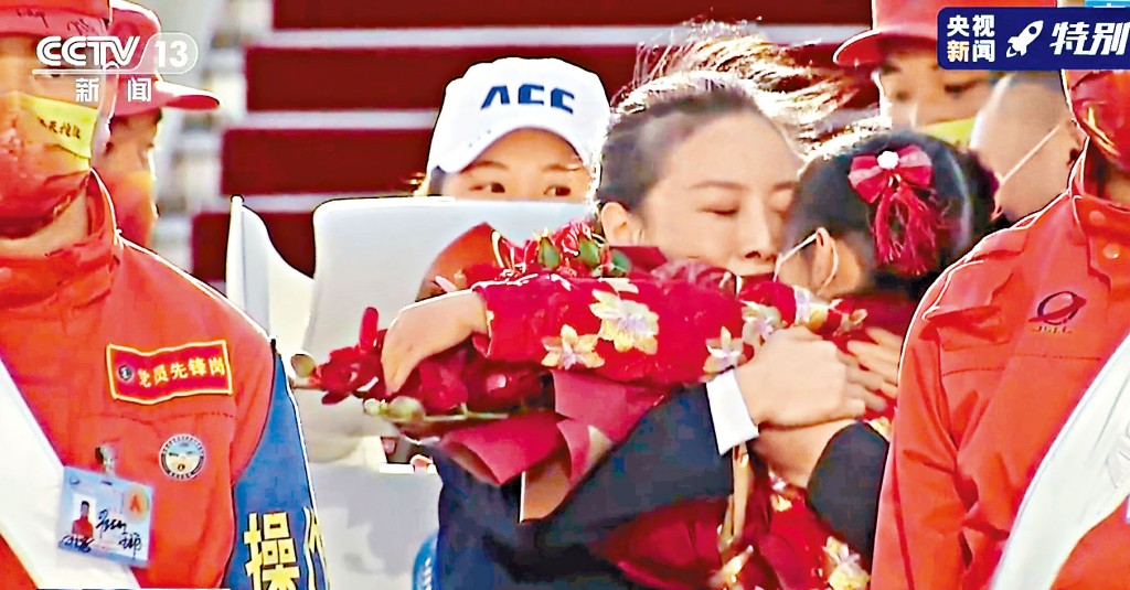 王亞平輕吻來接機的女兒，拿出一顆「星星」交給她。