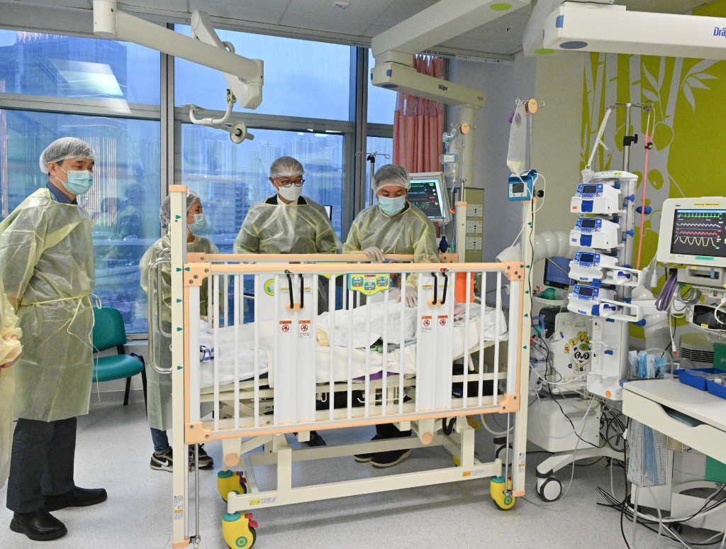   盧寵茂（右二）今日到兒童醫院探望去年底成功進行心臟移植手術的女嬰小芷希。政府新聞處圖片