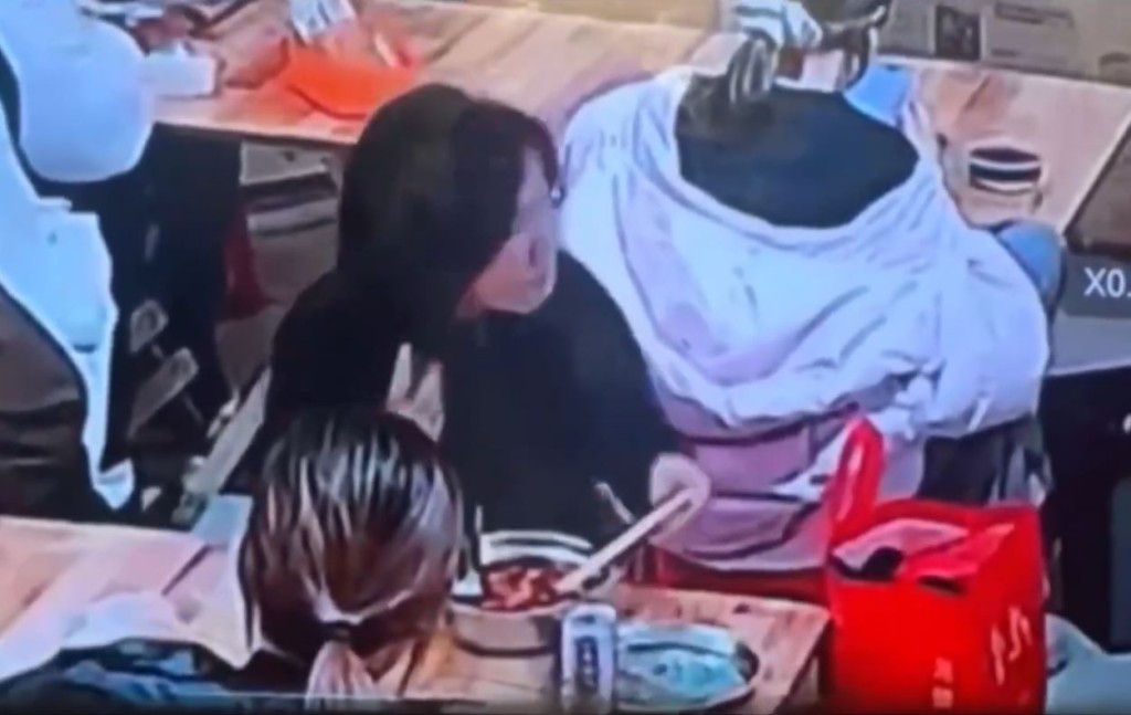 缺德黑衣女將螺螄粉湯倒入背座的羽絨衣帽內。