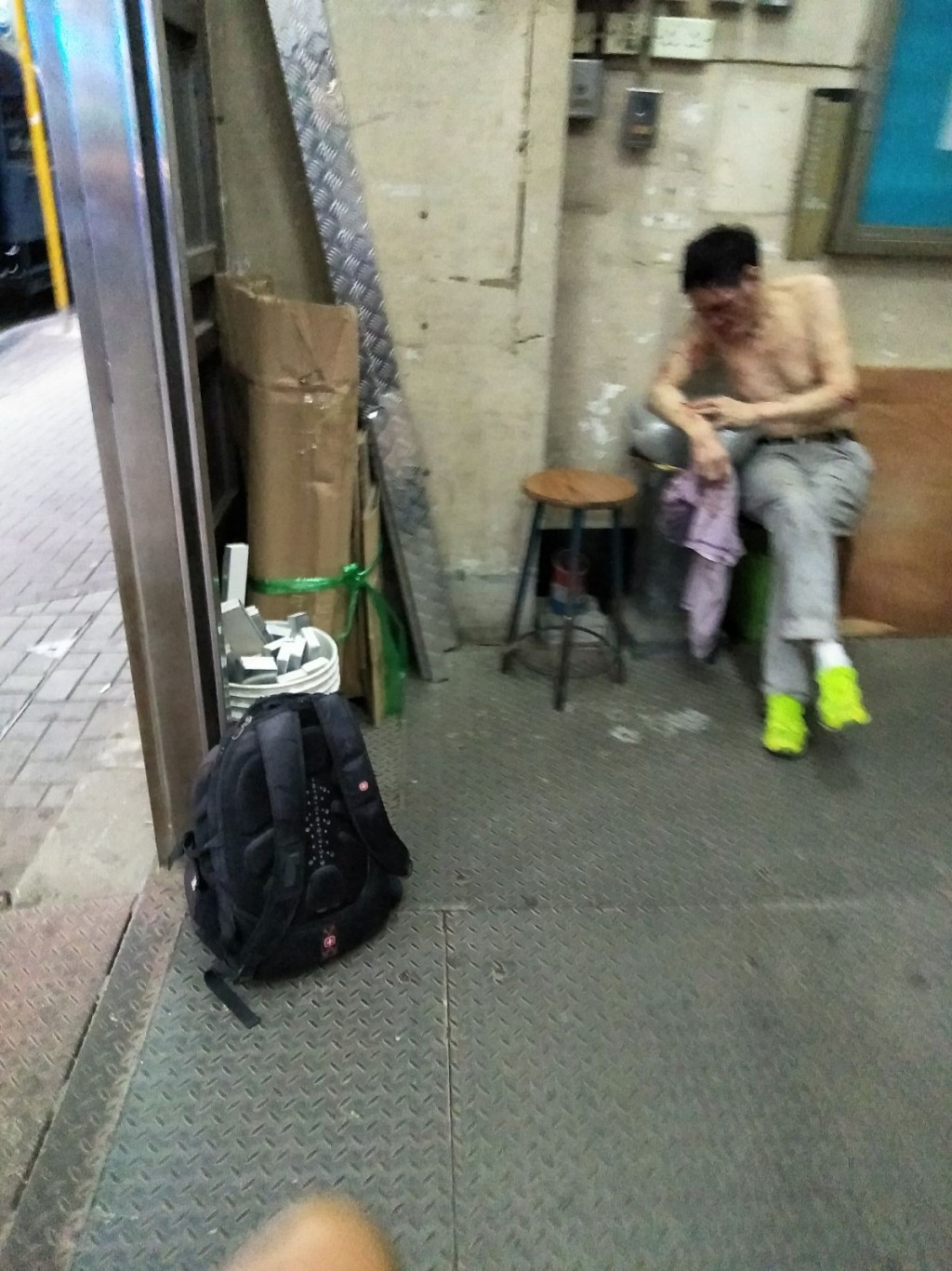 遇劫保安員被打至頭破血流,在現場等候救援。 讀者提供