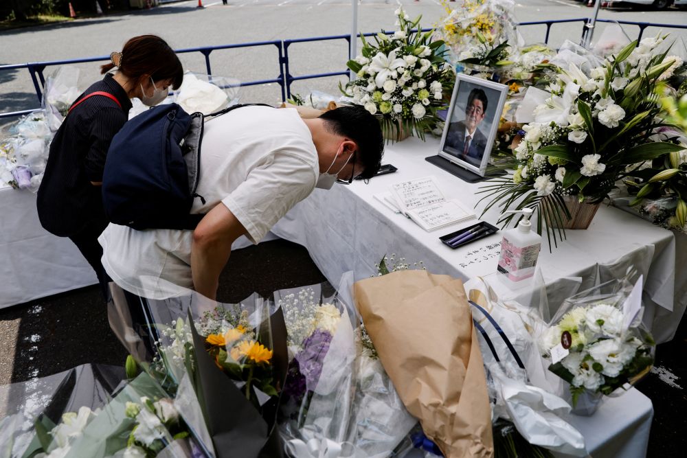 日本东京自民党总部，祭坛上放置了一张已故日本前首相安倍晋三的照片，供哀悼者鞠躬。路透社图片