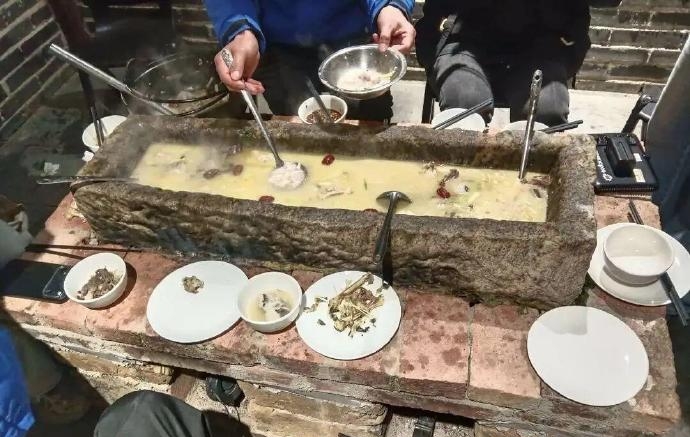 几位客人围桌“打边炉”,锅具竟是一个长约一米的青石槽。 几位客人围桌“打边炉”,锅具竟是一个长约一米的青石槽。