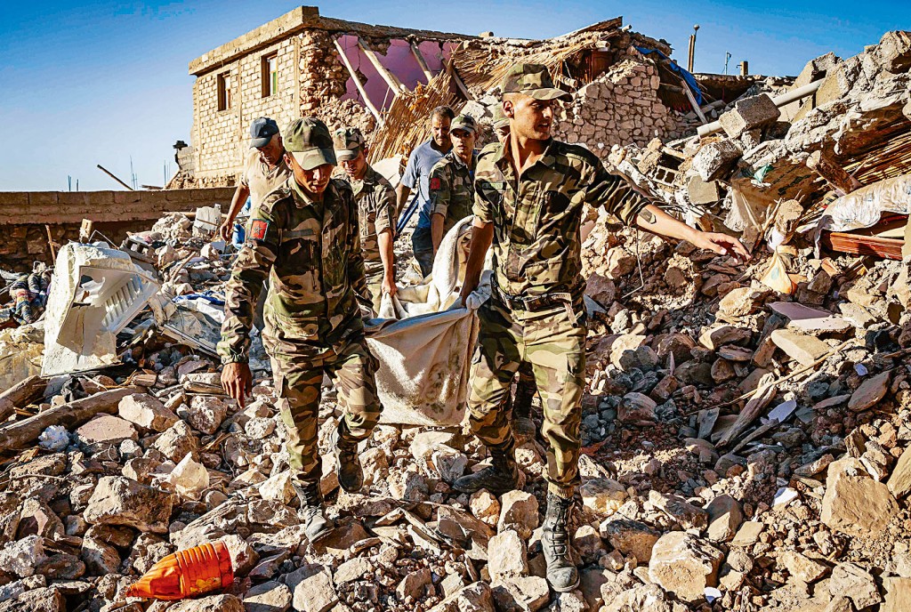摩洛哥士兵在马拉喀什附近山村瓦砾堆，挖出一具遗体。