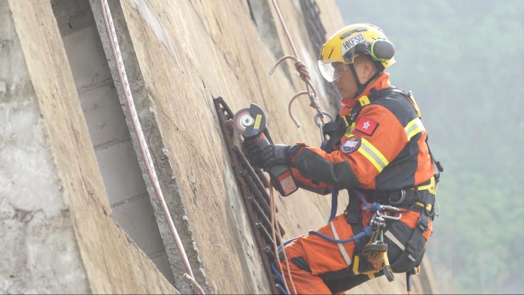 消防处灾难应变救援队队员于倾斜的建筑物拆破外墙架构以进行救援工作。政府新闻处