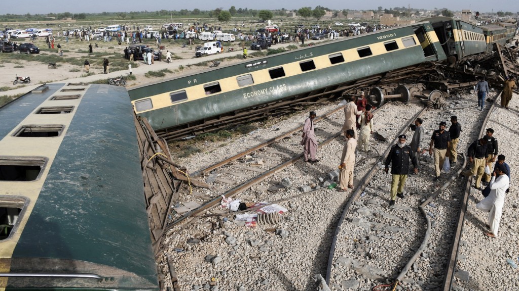 巴基斯坦警員聚集在翻側脫軌的火車旁。 路透社