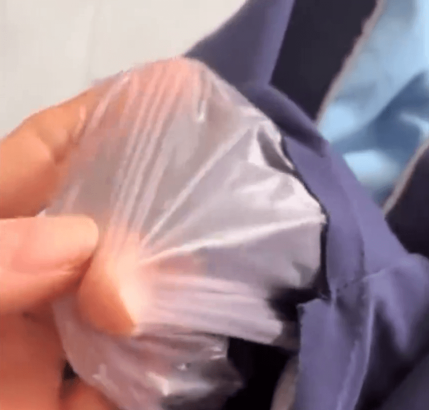 网民发视频称小学校服内层发现胶膜。