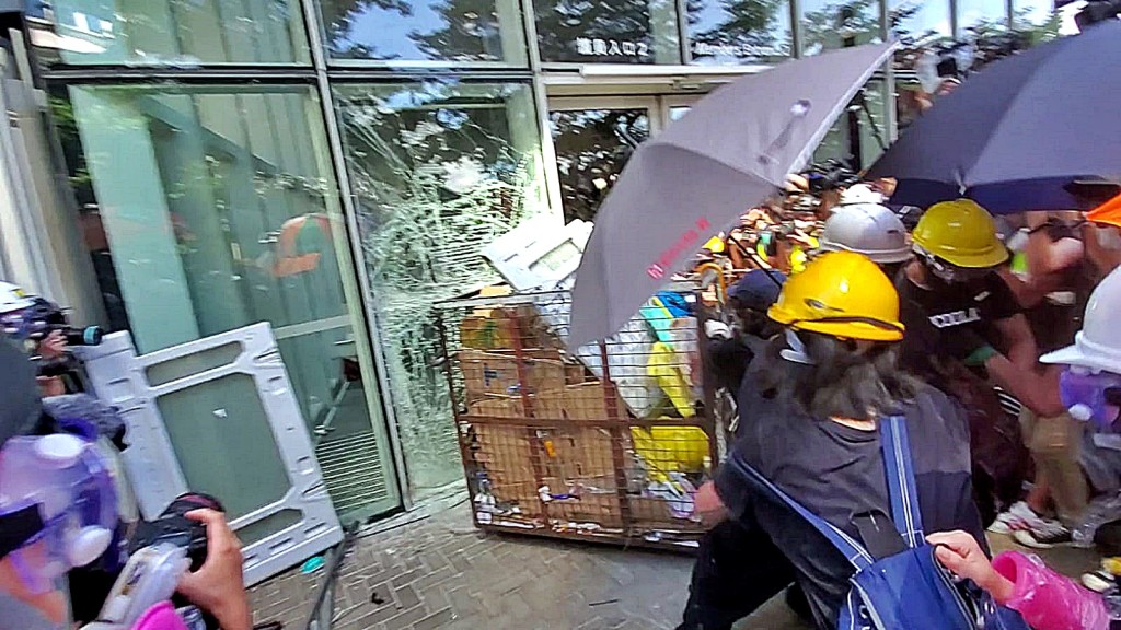 示威者以鐵籠車衝擊玻璃門。