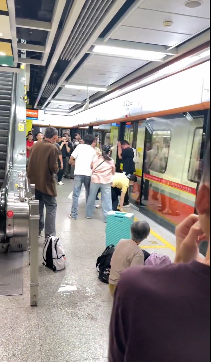 被喷中辣椒水乘客逃出车厢后，在月台用瓶装水洗眼。