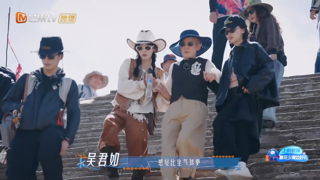吳君如由周冬雨與同行隊員左右挽扶前行，坦言攀爬陡峭石階比坐熱氣球更加驚險。