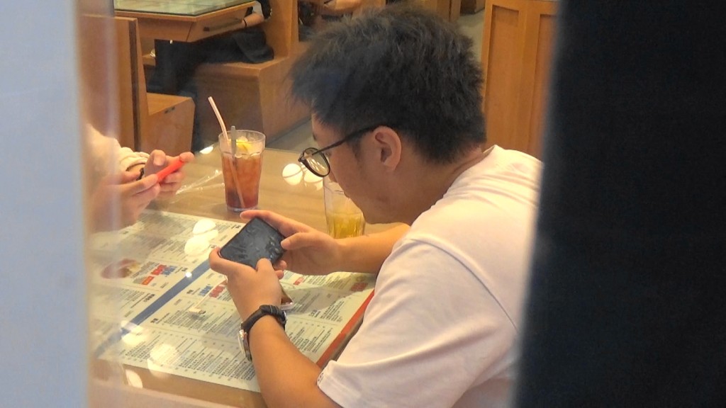 鍾培生入到冰室冇耐就掛住打機。