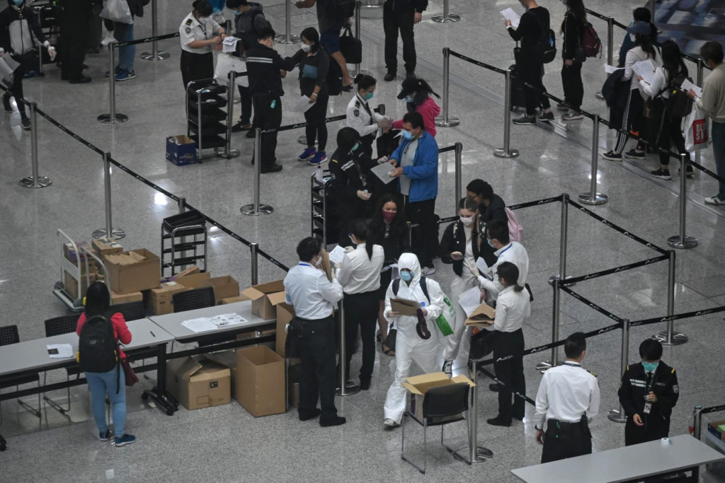 机场不时见到有乘客穿上全套保护衣。