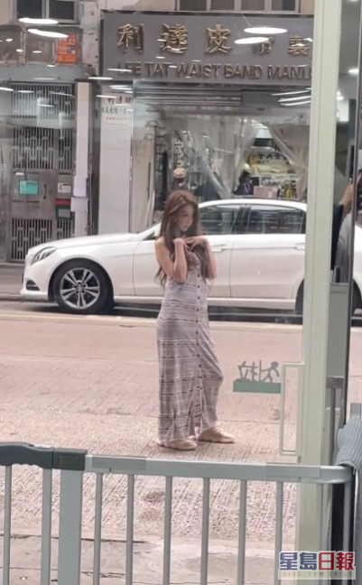 穿连身长裙的薛凯琪在马路上摆Pose拍照。