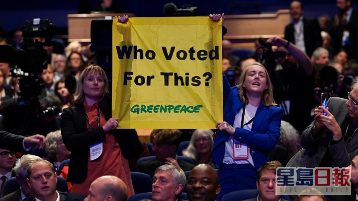 有绿色和平成员在保守党年会上举起标语，抗议卓慧思内阁不重视环保议题。路透社图片