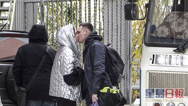 俄罗斯宣布局部动员令，有被徵召者登车离开前吻别至亲。AP资料图片