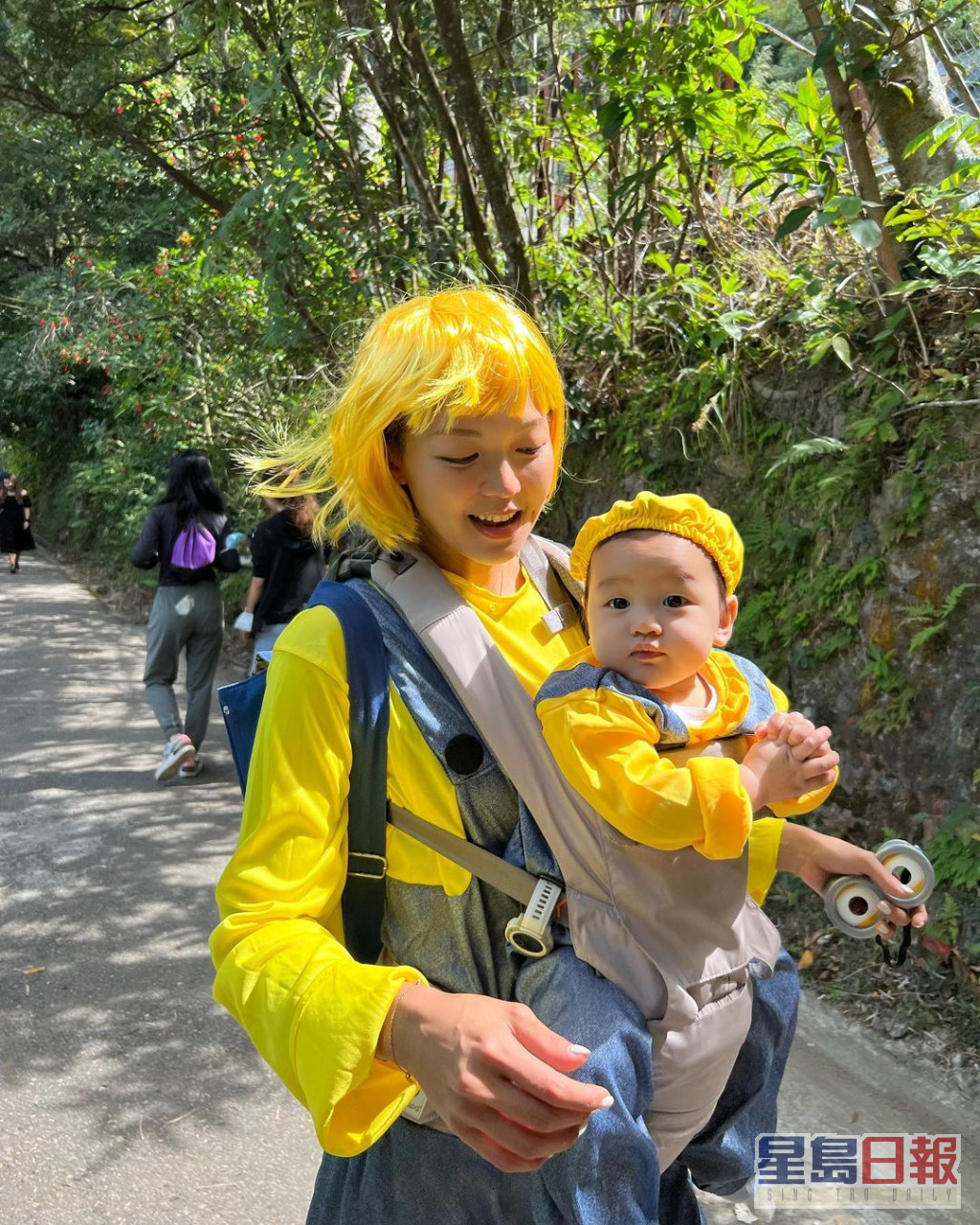 洪永城老婆梁諾妍戴上黃色假髮，抱着囝囝一齊行山過萬聖節。