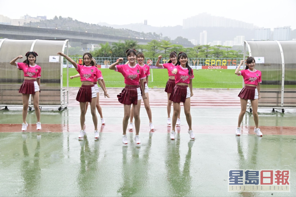 樂天女孩穿上粉紅色上衣及短裙褲，在雨中表演。