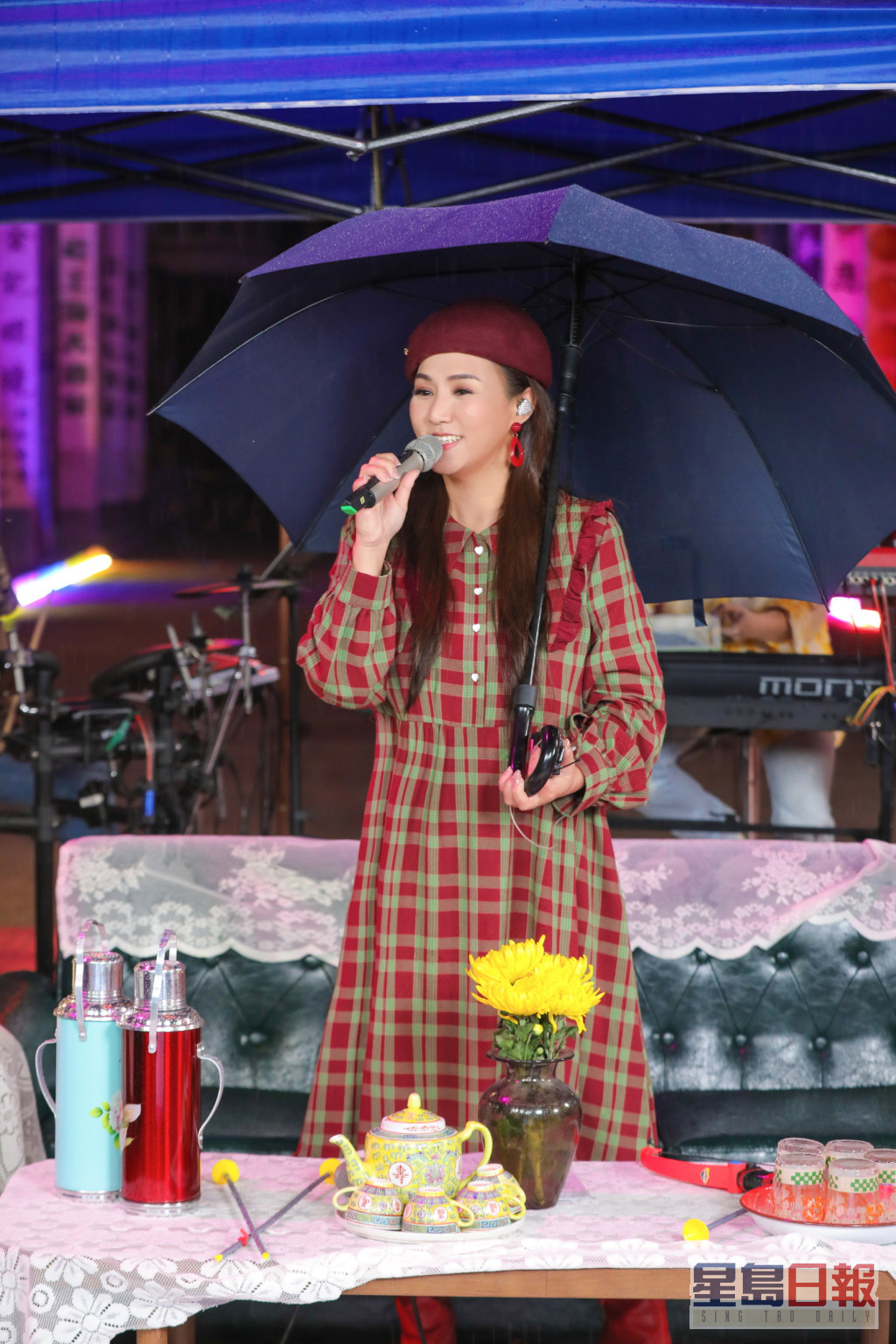 演出期间突然下起雨来，但小恩子未有放弃。