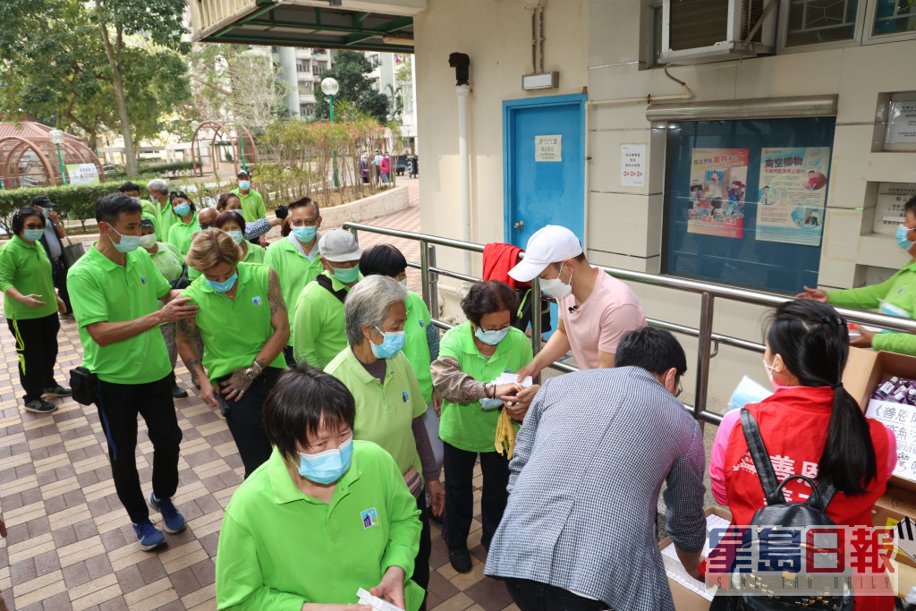 小西灣邨的清潔工人，在嘉年手上接過物資。