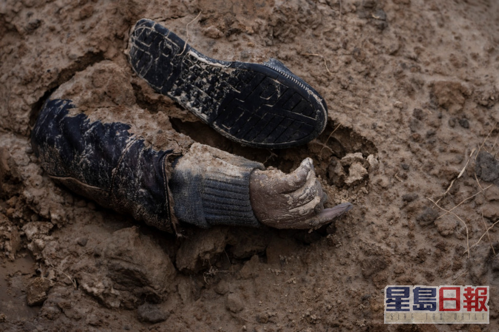 有平民被埋在泥下只露出一隻手。AP