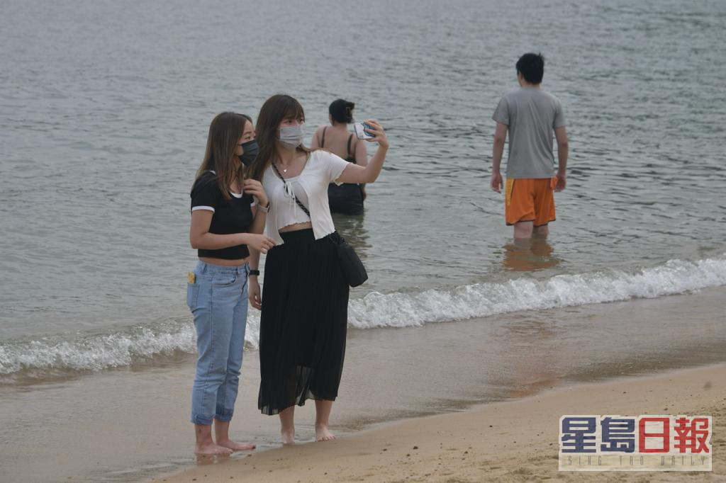 浅水湾沙滩人声鼎沸，市民戏水消暑。