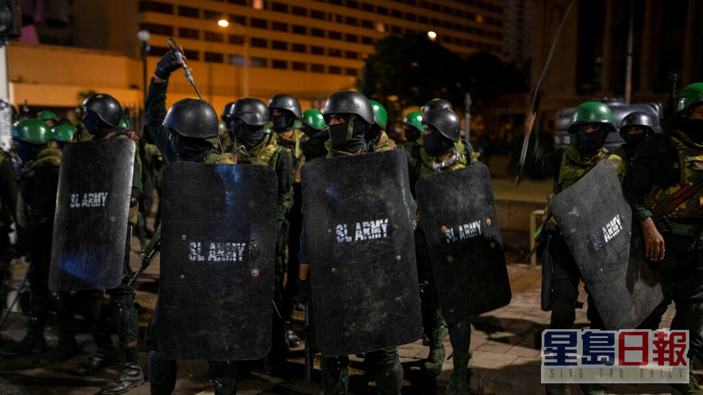 部分人員手持警棍及步槍，進逼堵塞通往總統府街道的示威者。AP圖片