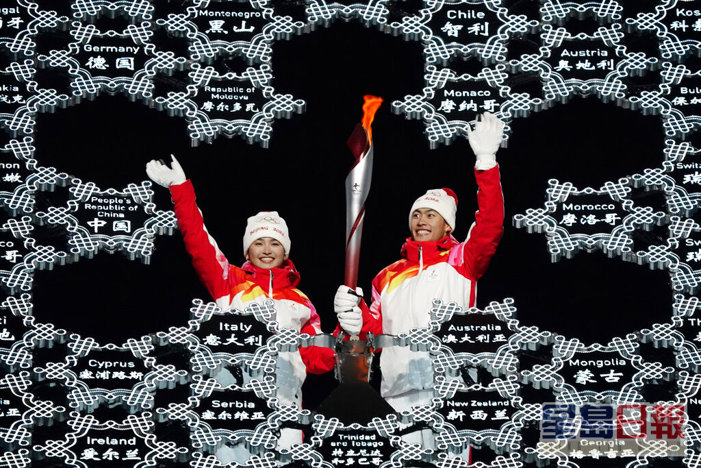 冬奥最后2名火炬手迪妮格尔衣拉木江（左）及赵嘉文一同传递火炬。美联社图片