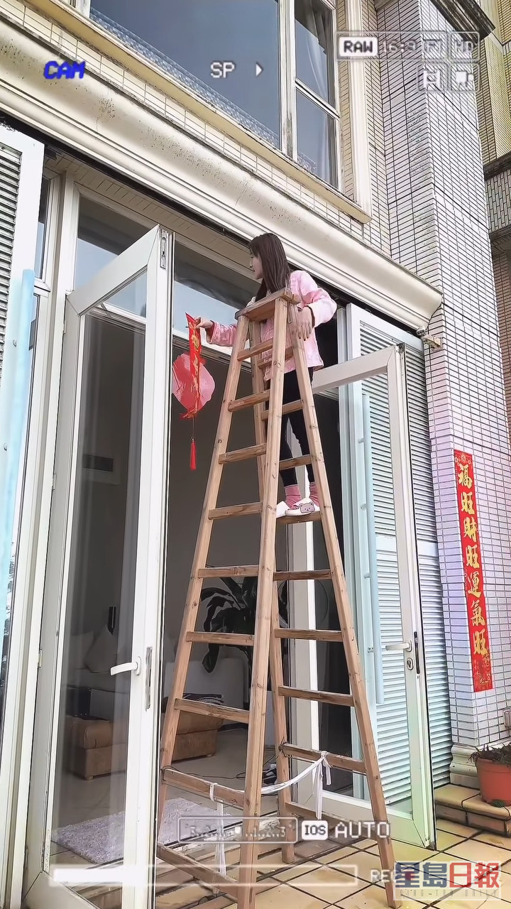 林夏薇于大门顶贴上「吉祥如意」挥春应节。