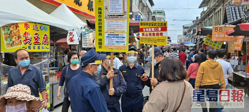 警员在老街举牌呼吁民众戴好口罩。旗山警分局fb