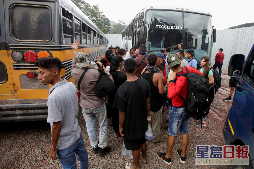 這些移民等候上巴士往其他城市。REUTERS