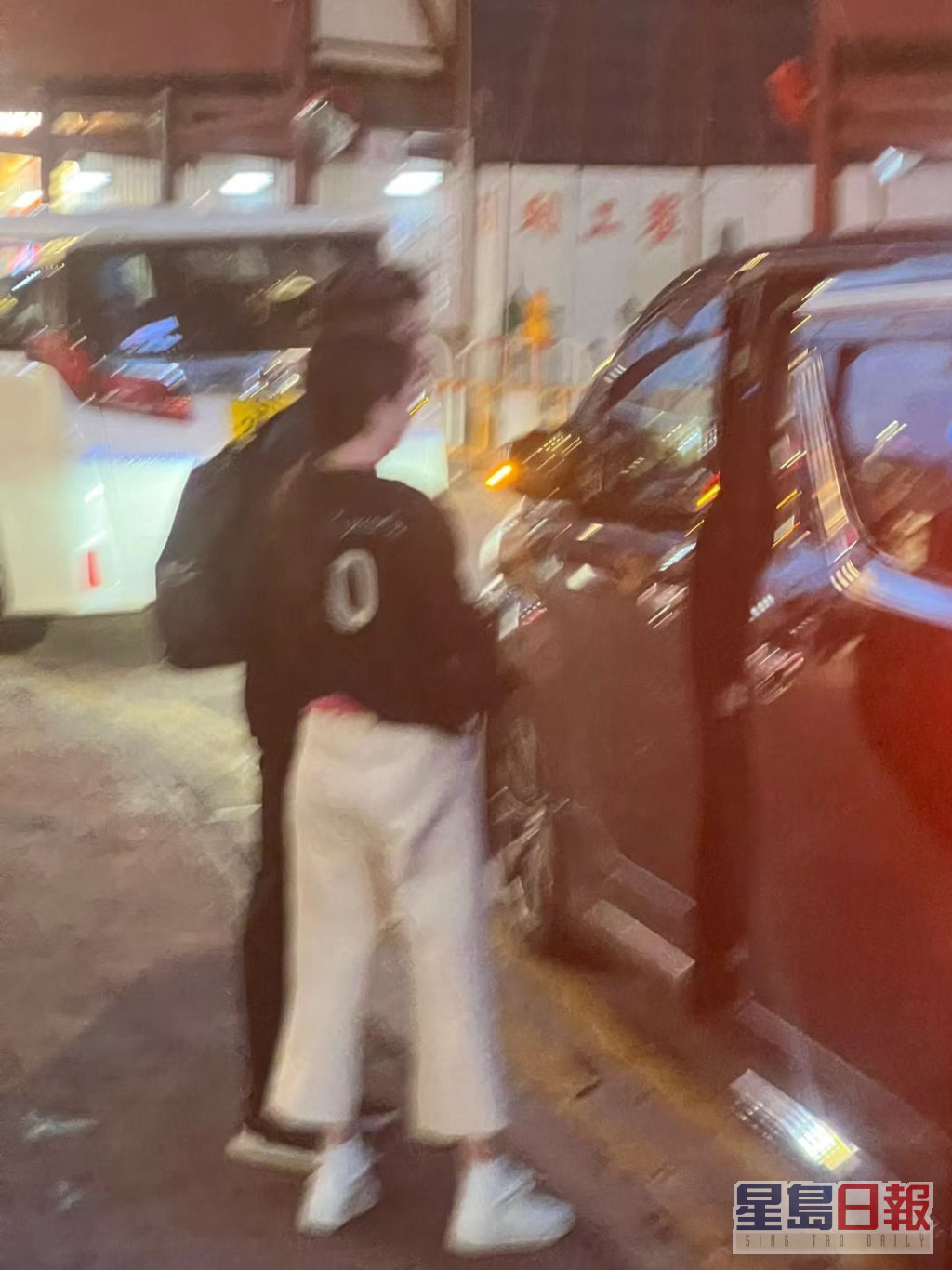 全黑Look孭黑背囊的郭富城，與穿深色外套襯白色八分褲的方媛，站在車旁等自動門慢慢打開。