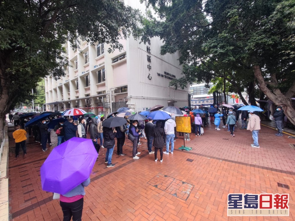 市民在微雨下繞住中心外圍排隊。梁國峰攝