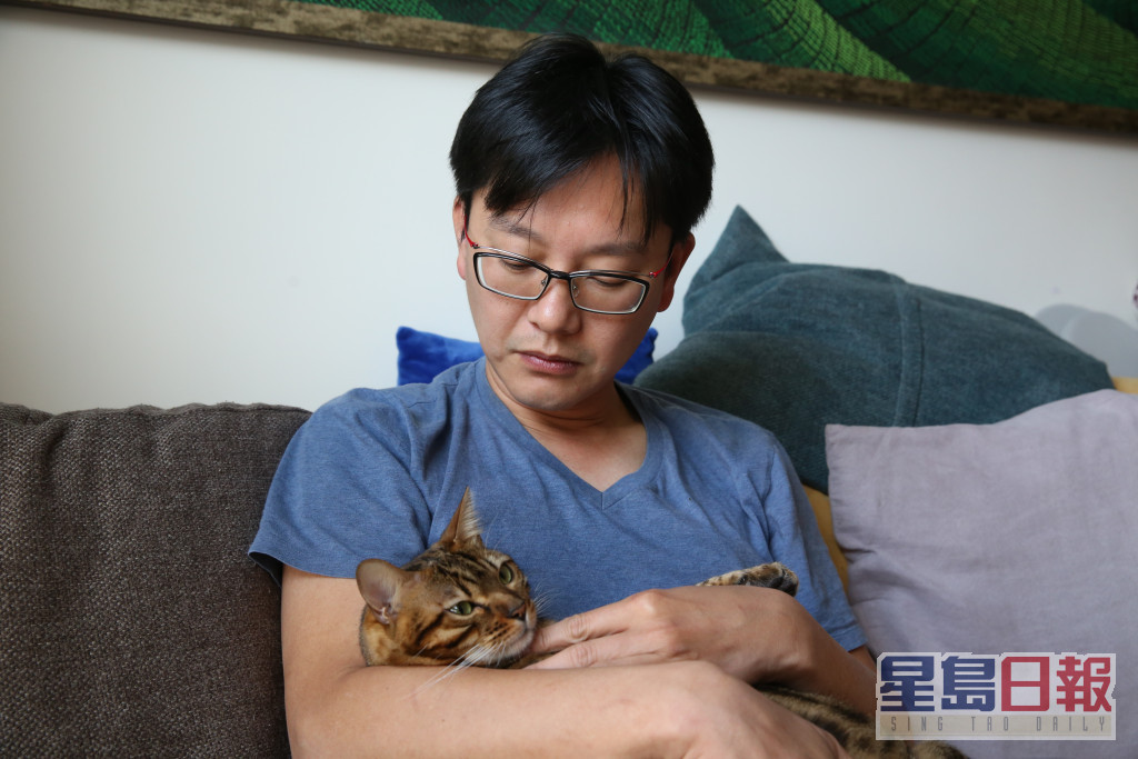 周英杰手抱蔡天鳳生前喜歡的貓兒懷念故人。劉漢權攝