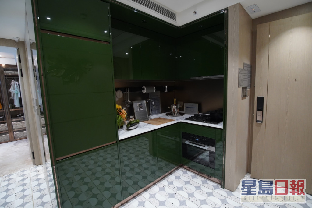 開放式廚房廚櫃用上深綠色，貫徹全屋主題。（2座28樓B室）