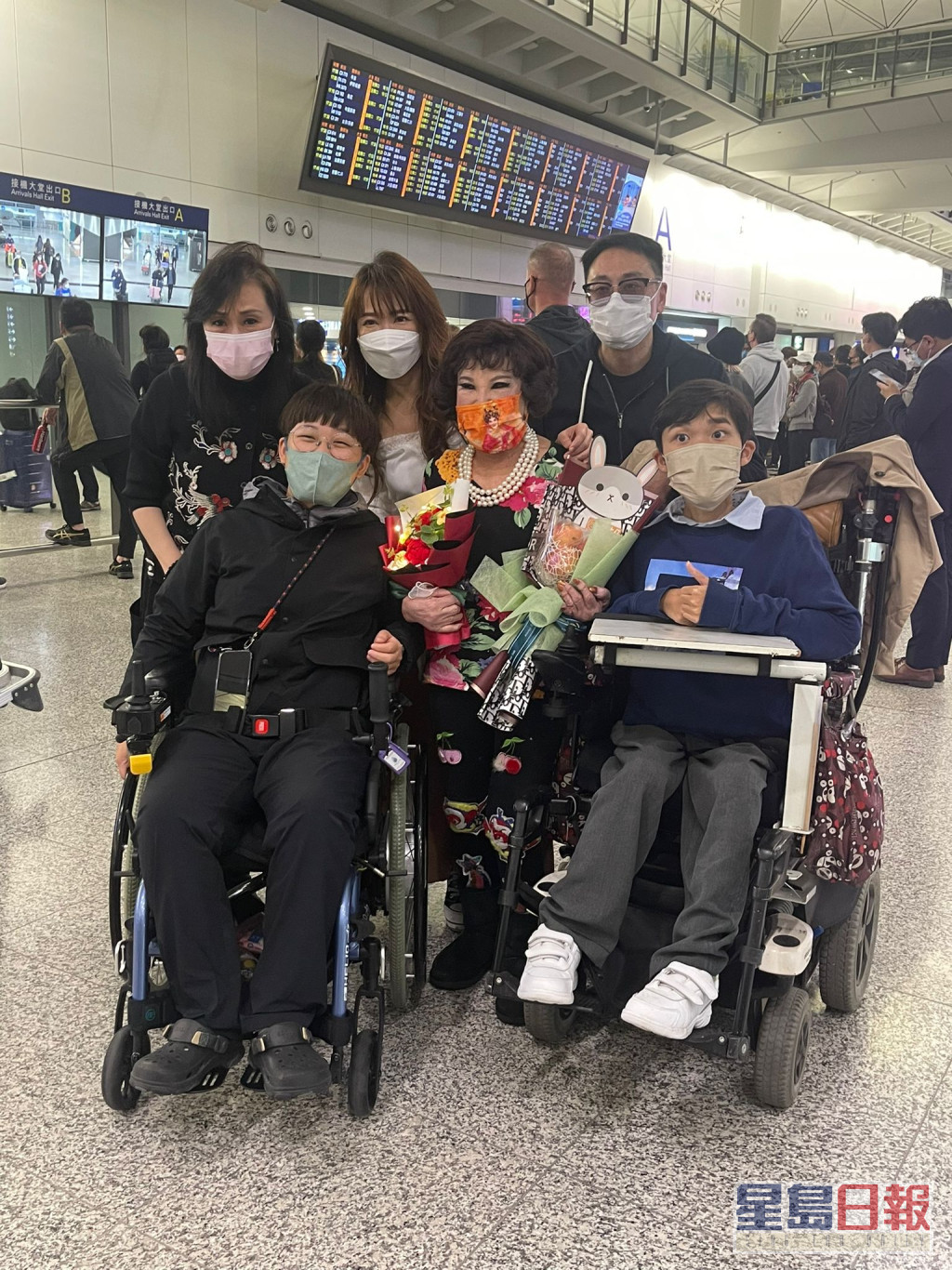 契仔杨峰及契女徐宝凤前往机场接机，同行的还有两位坐住轮椅嘅罕见疾病小朋友。