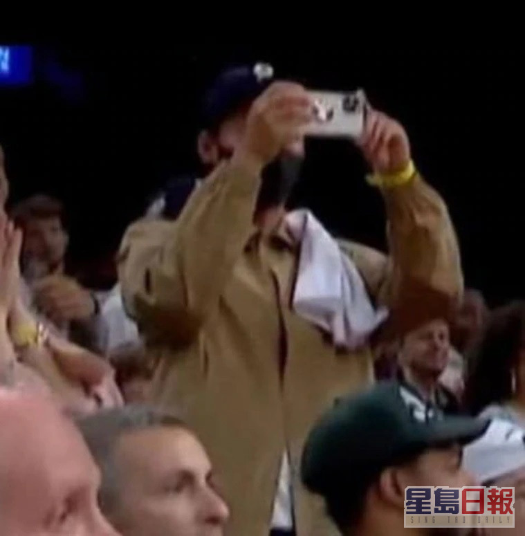 玄彬站起为NBA赛事拍照，表现兴奋。