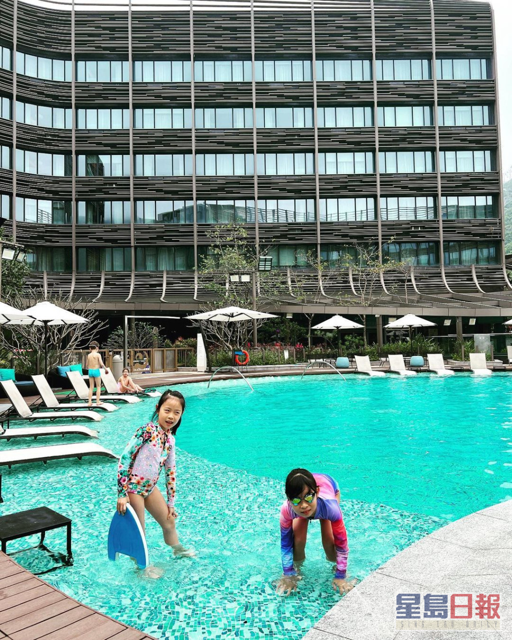 两姊妹喺酒店泳池玩水。