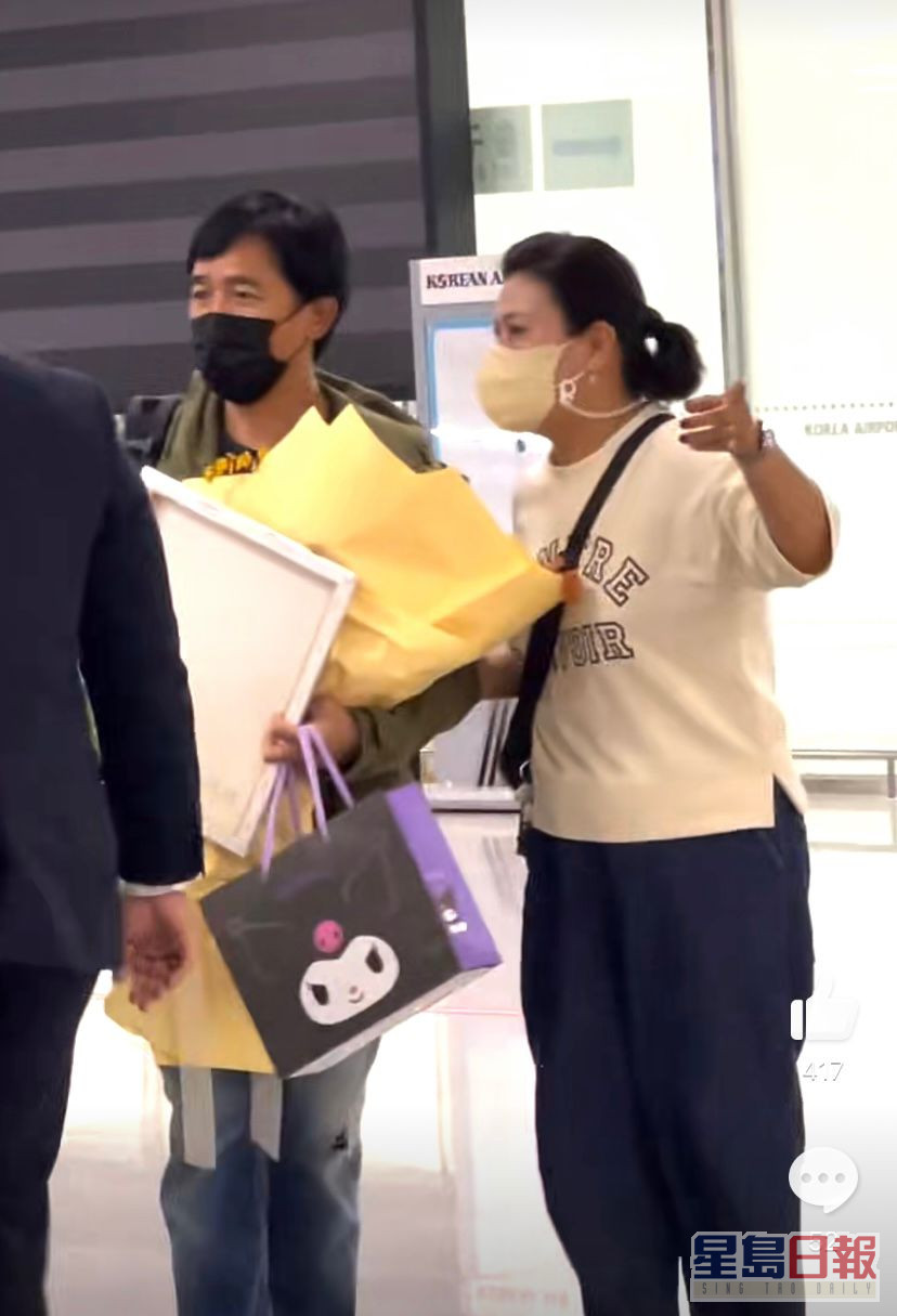 梁朝偉在釜山機場一落機就主動上前收影迷送的花。