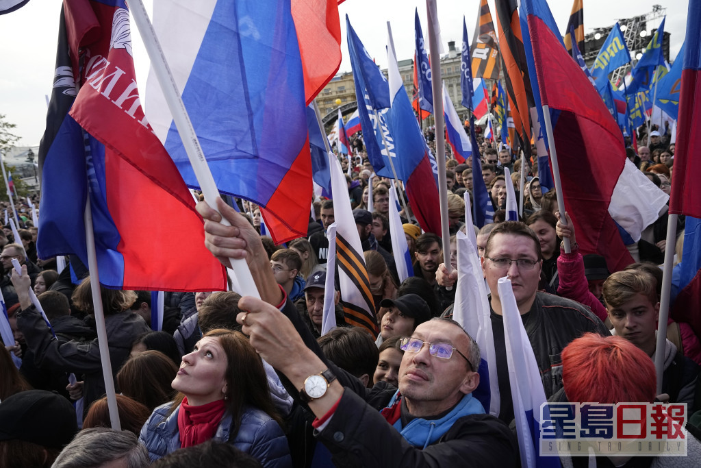 民众举起俄罗斯国旗参加集会。AP