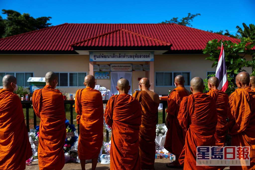 泰国佛教僧侣在枪击案托儿所外祈祷。路透社图片
