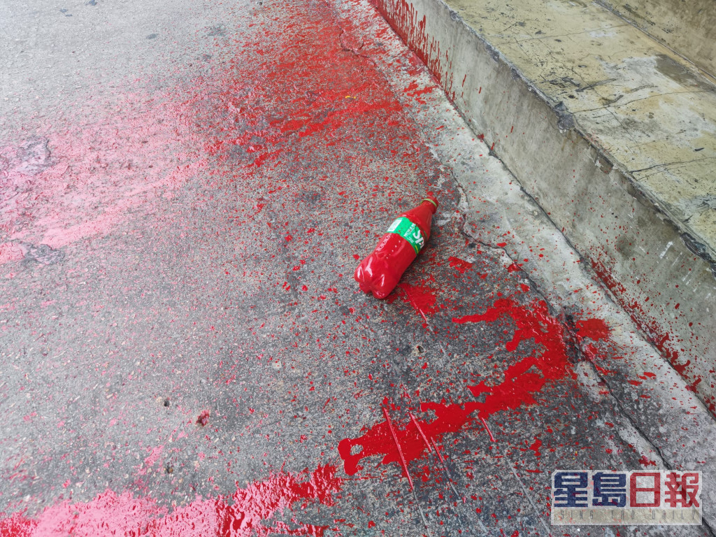 地上遗下一个装载有红油的胶樽。梁国峰摄